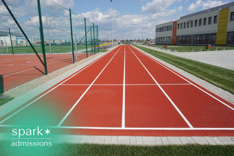 Outdoor running track beside a school athletic facility and sports fields