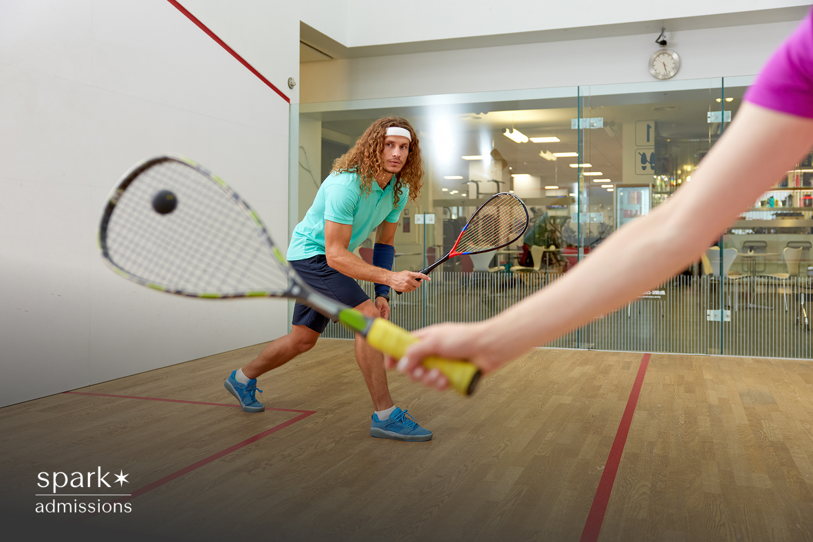 A player in action hitting the ball during a squash game on the court.