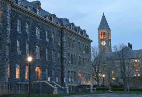 The exterior of several stone-faced buildings at dusk, just as the lights are coming on.