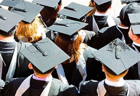 students lined up for high-school graduation in their cap and gown.