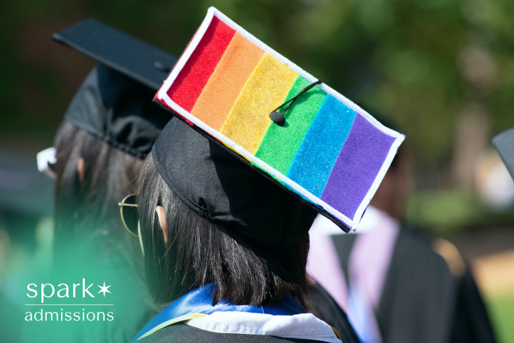 Graduate wearing a decorated rainbow Pride graduation cap during a college commencement ceremony, representing LGBTQ+ inclusion, diversity, and academic achievement.