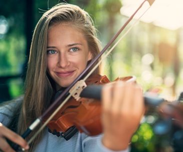 Close-up of high school girl with long blonde hair playing violin