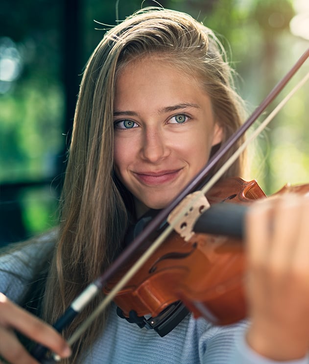 Close-up of high school girl with long blonde hair playing violin