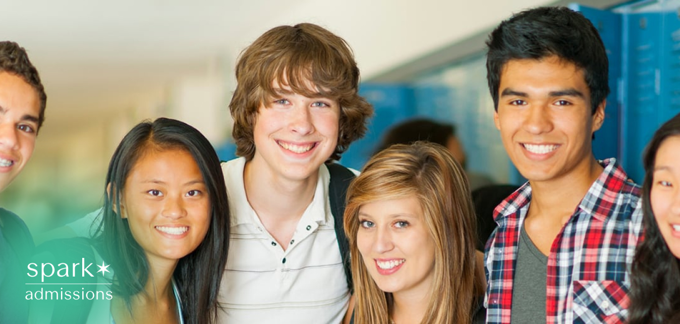 Diverse group of smiling high school students standing together in a hallway by school lockers.