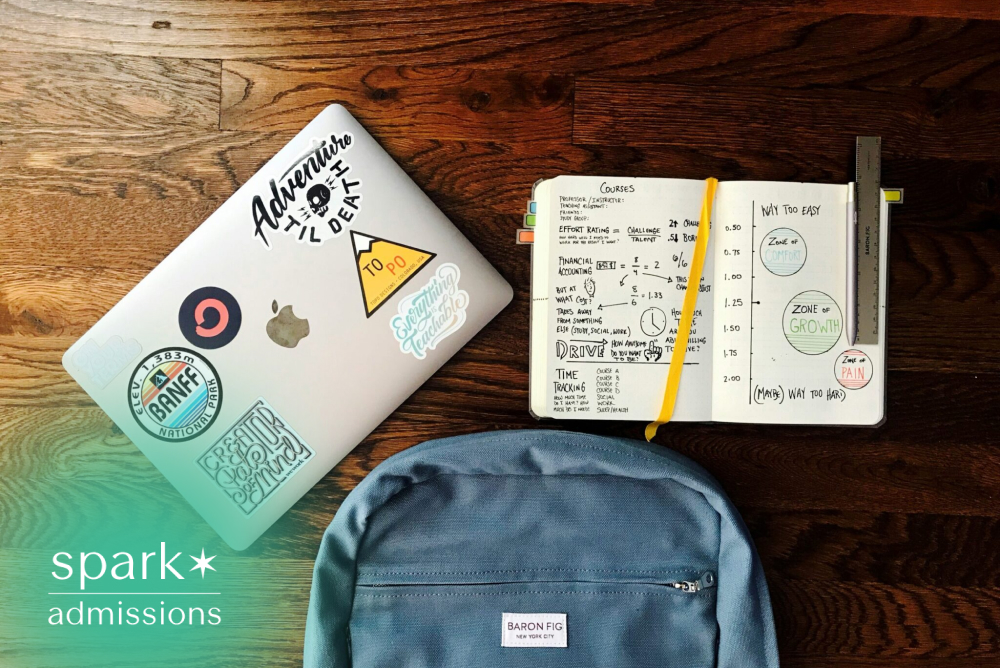 Student study setup with laptop, notebook, backpack, and planner arranged on a wooden floor.