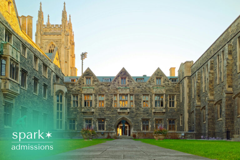 Historic college campus courtyard with Gothic-style academic buildings and green lawn