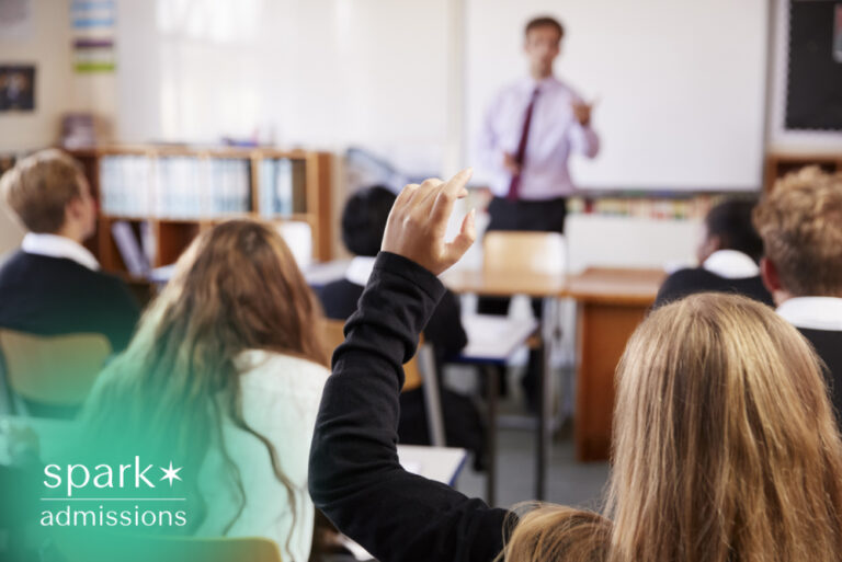 Student raising a hand to answer a question during a classroom lesson