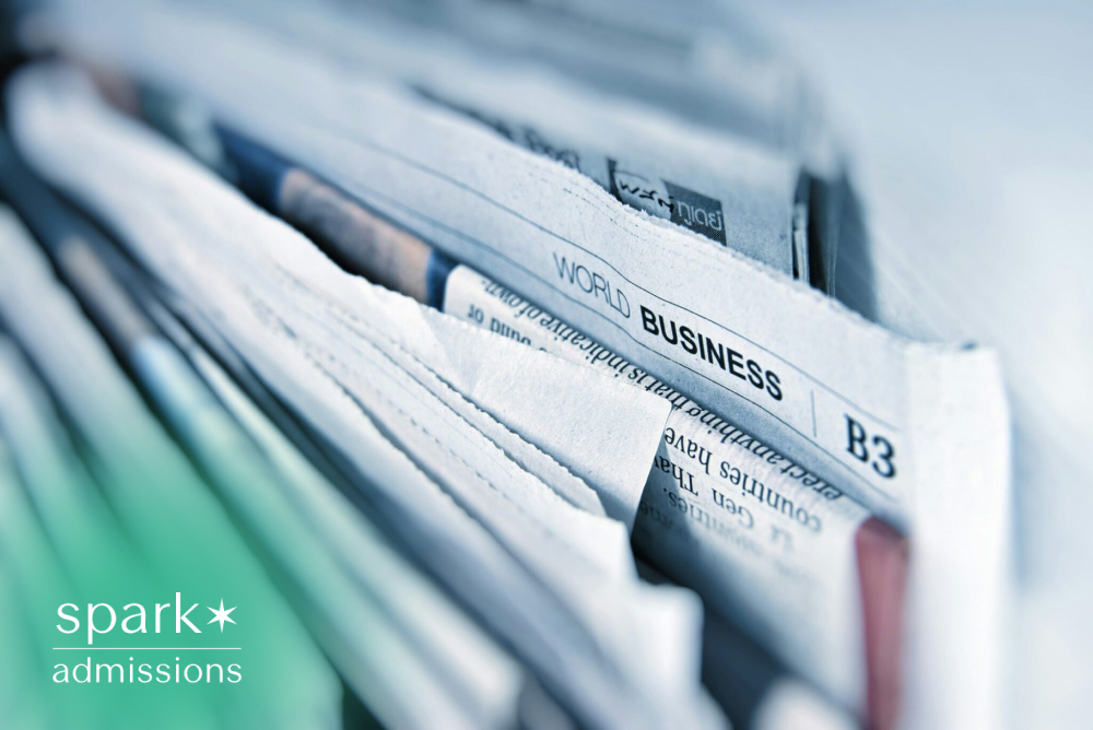 Close-up of stacked business newspapers highlighting world business news, financial markets, economic trends, investing, entrepreneurship, and current events.