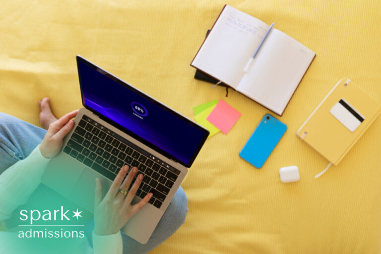 Student using laptop with notebook and study supplies on a yellow bed