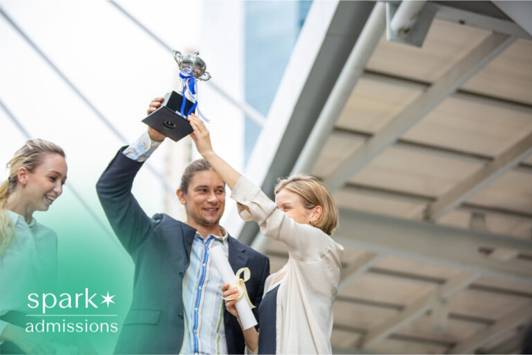 Students celebrating an academic award with a trophy
