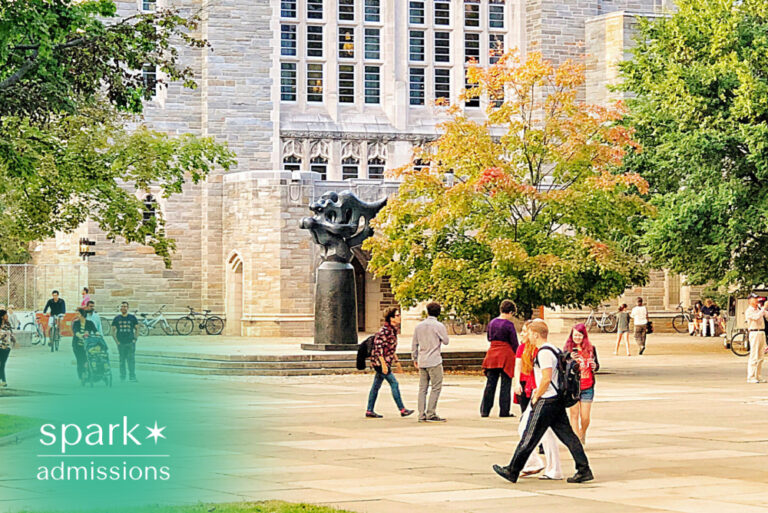 Students walking across a university campus near a historic building