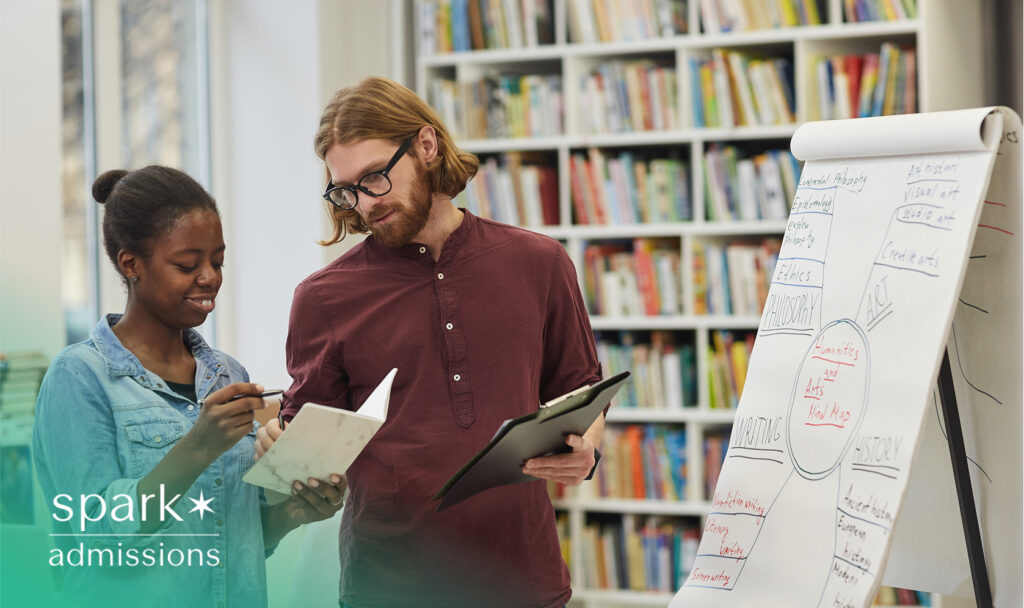 Teacher and student meeting with white paper stand displaying study material in library setup