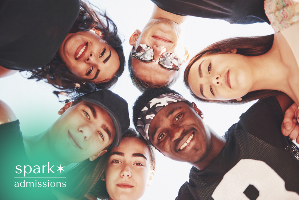 Diverse students looking down together in a circle