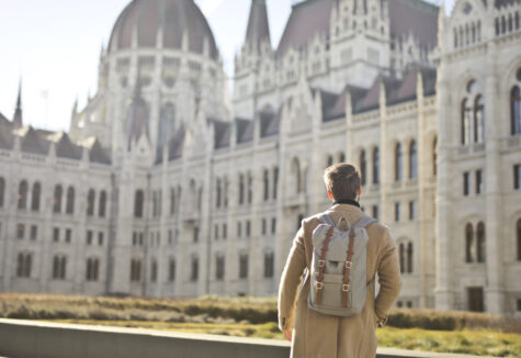 Student facing toward a school building, symbolizing ambition and future goals