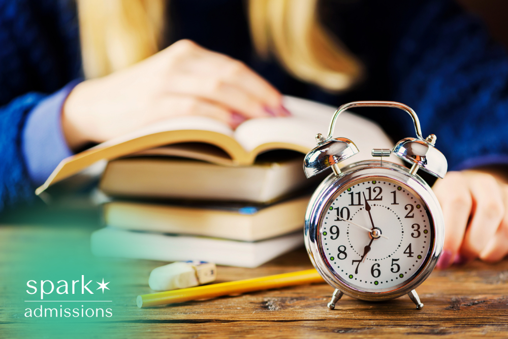 Student studying with books, pencil, and alarm clock on desk