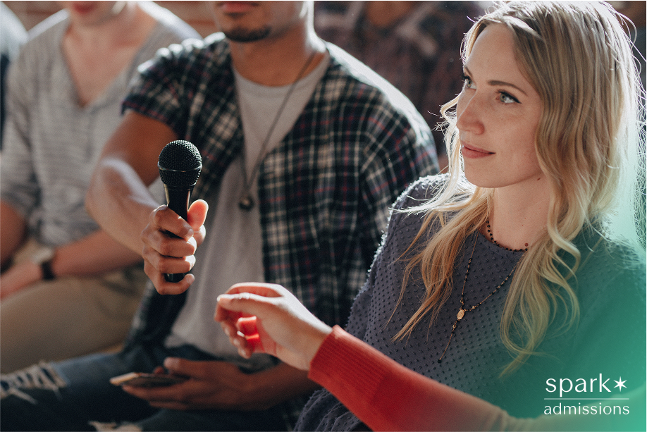 A student reaches for a microphone during a Political Science Extracurriculars group discussion