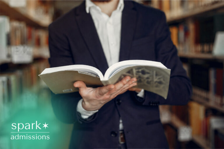 Admissions consultant reading a book in a library