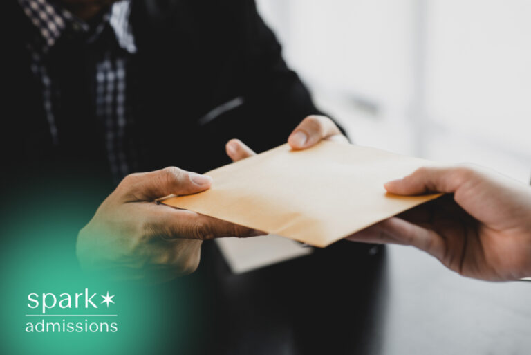 Person handing over an admissions letter during a meeting