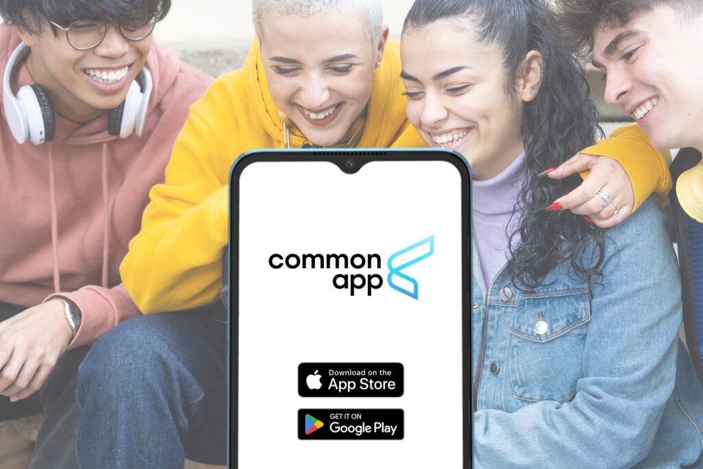 Diverse group of college-age students smiling while viewing a smartphone displaying the Common App interface, highlighting mobile access to Common App transfer applications.