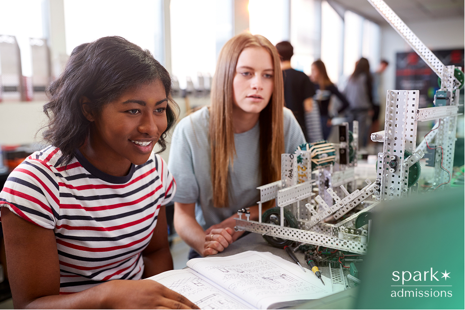 Two Female College Students Building Machine In Science Robotics Or Engineering Class