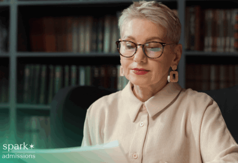 Female college admissions officer looking over student application paperwork at her desk