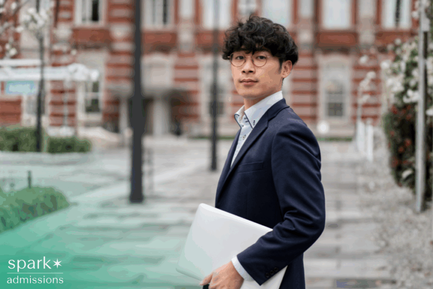 Asian male business college student holding a laptop