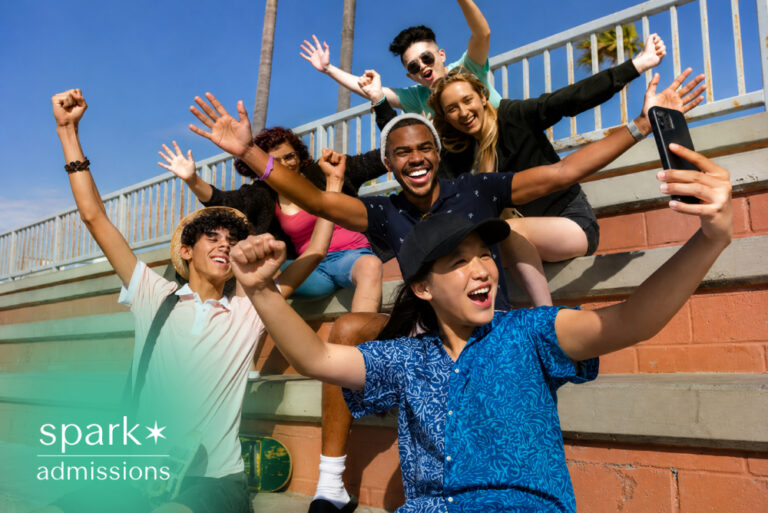 Diverse students taking a selfie together on campus steps