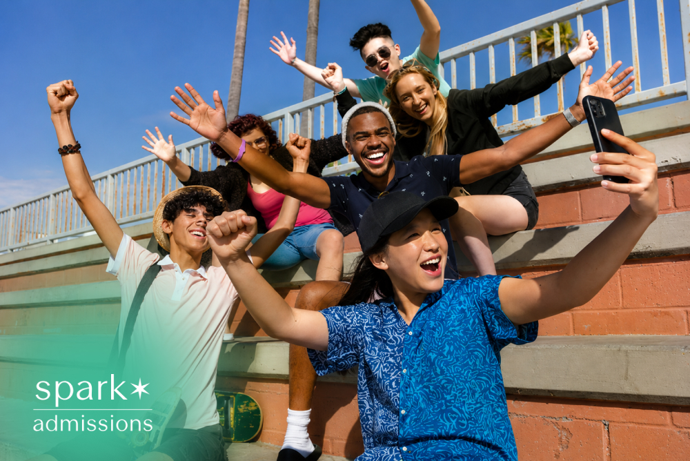 Diverse students taking a selfie together on campus steps