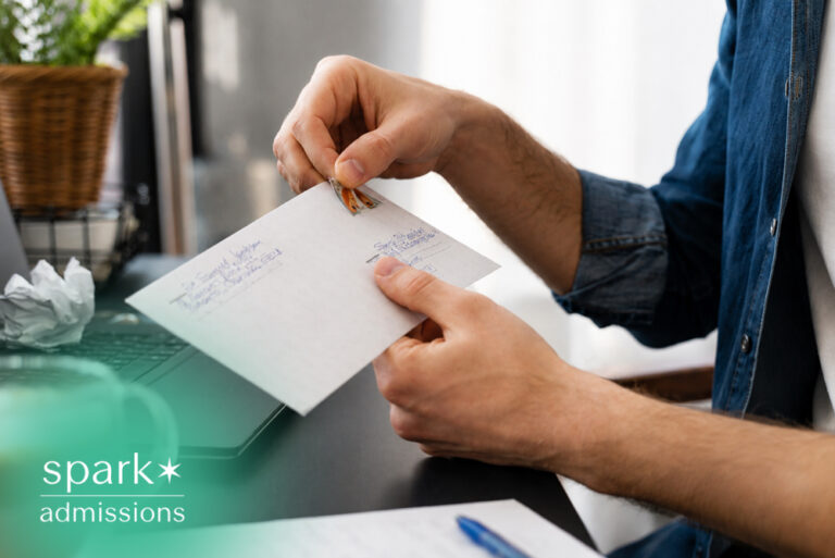 Person placing a postage stamp on a handwritten letter