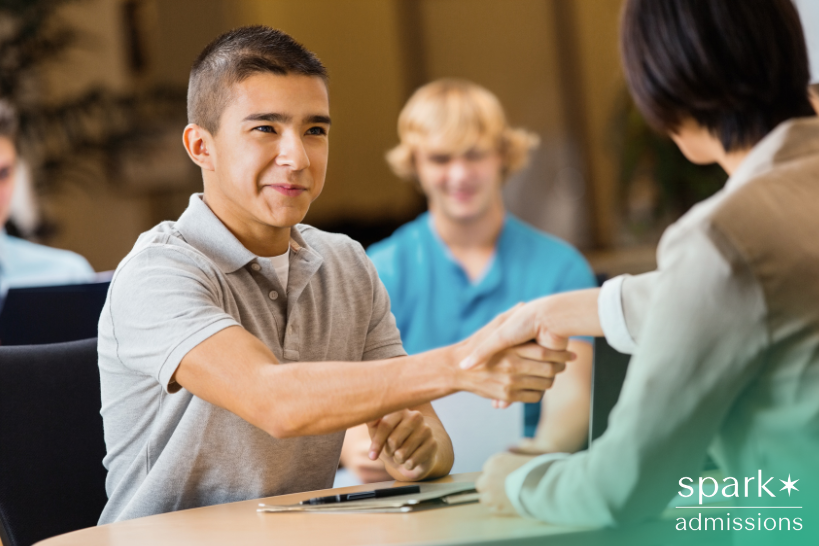 High school student shaking hands with private school admissions officer.