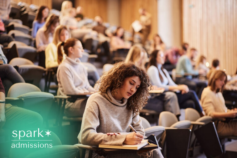 Student taking notes in a college lecture hall during class