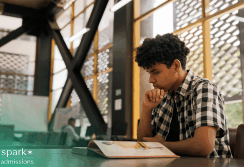 High-achieving student with autism studying and reading a book while preparing for college admissions
