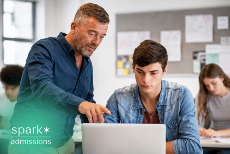 Teacher helping a student use a laptop during an online learning session