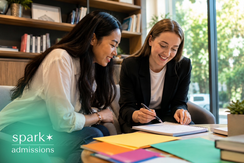 Counselor helping a student review notes and folders for college admissions planning