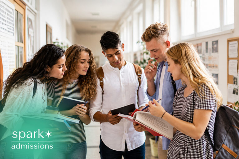 Students discussing college plans with books and notes in a school hallway