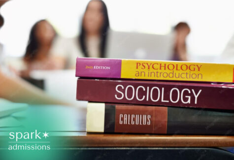 Psychology sociology and calculus textbooks stacked on a classroom desk