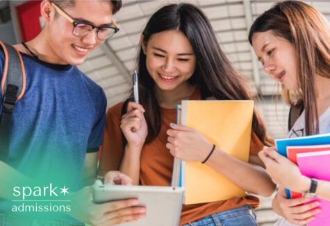 Students reviewing college application details together on a tablet