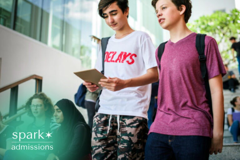 Students reviewing college planning details on a tablet while walking on campus