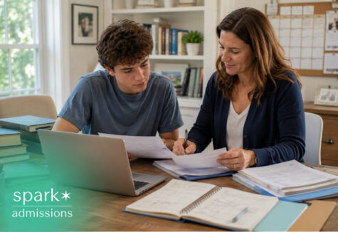 Parent helping a teenager review academic paperwork and school planning documents at a home study table with a laptop.