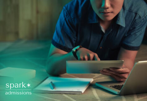 Student using a tablet and laptop while studying with books and notes