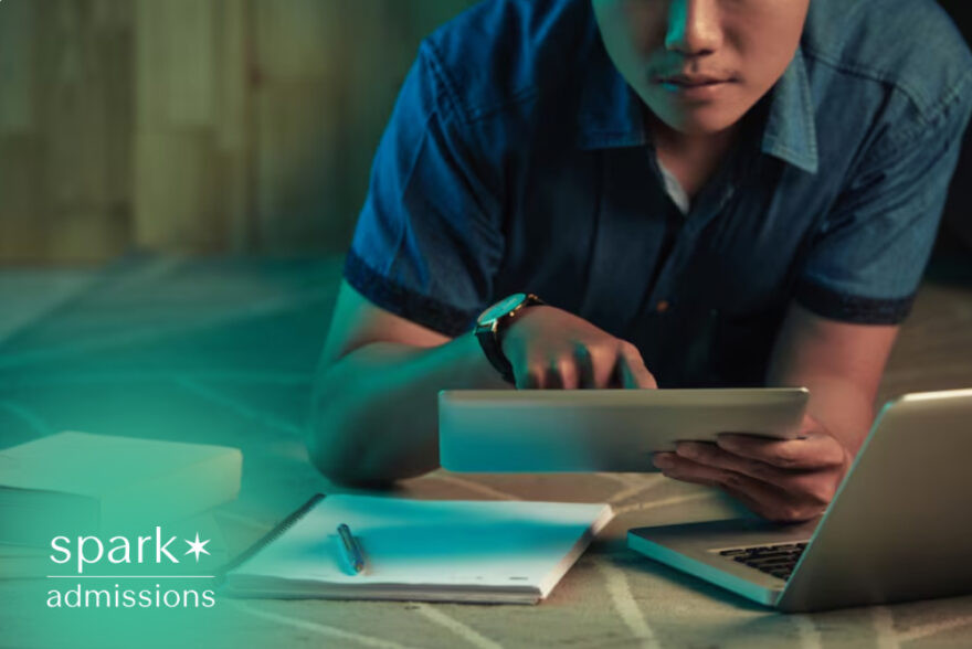 Student using a tablet and laptop while studying with books and notes