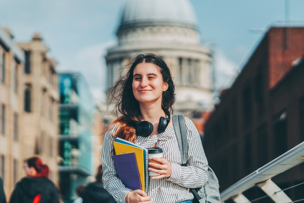 College student carrying books and a backpack, representing college admissions planning and consulting.