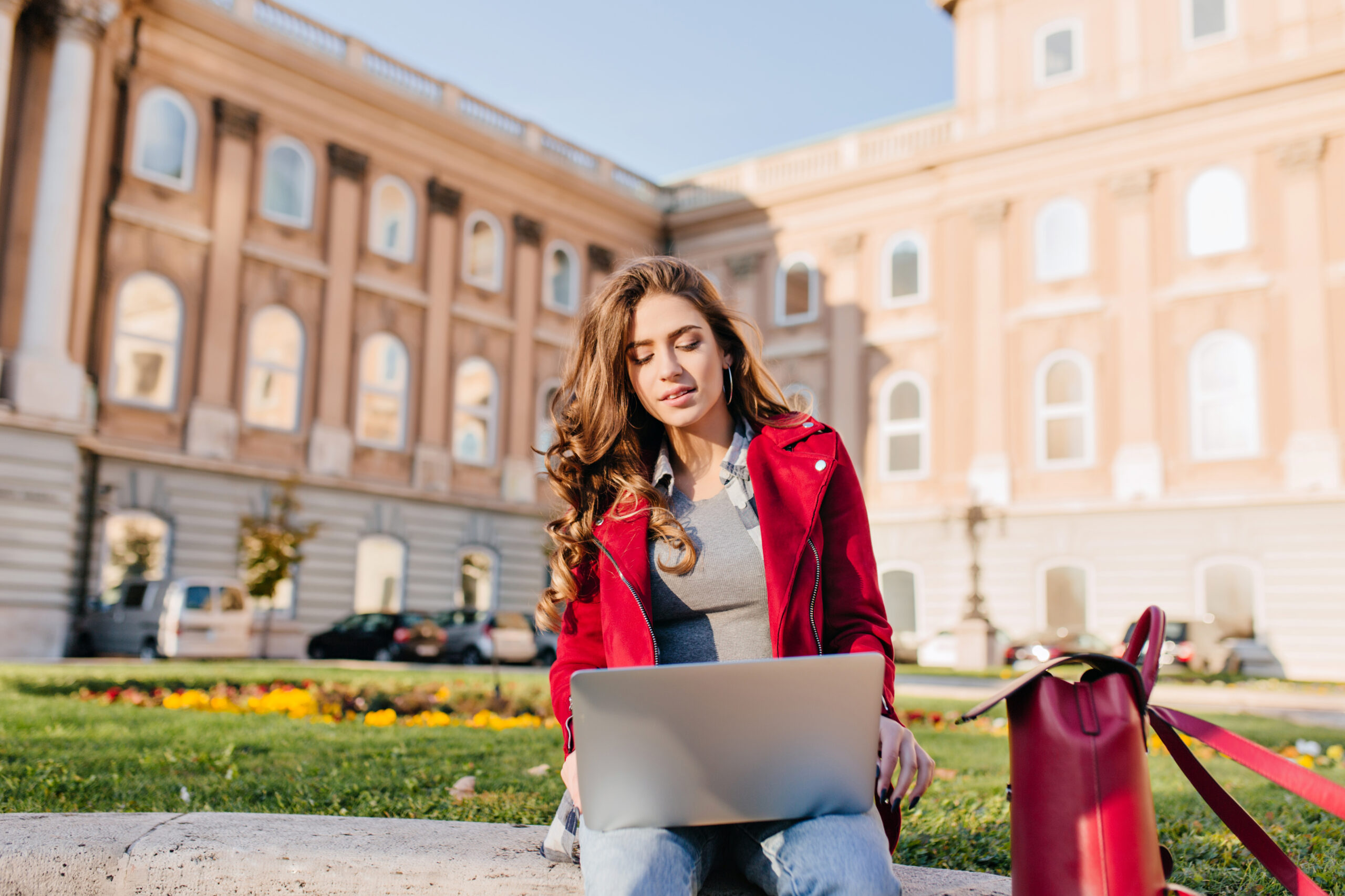 College student using a laptop on campus while working on a UC application.
