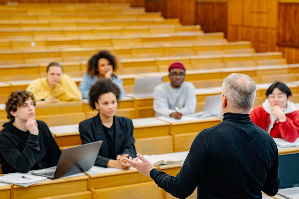 University students in a lecture hall representing the UC admissions selectivity system.