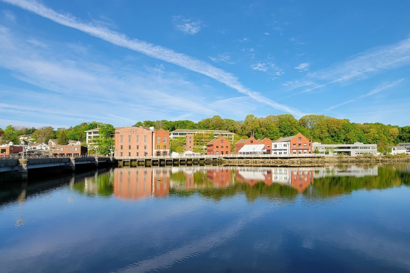 Scenic waterfront view of Westport, Connecticut, with historic buildings reflected on the water.