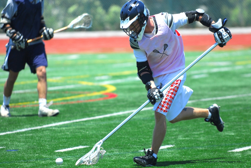 High school lacrosse player competing during a game for college recruiting exposure.