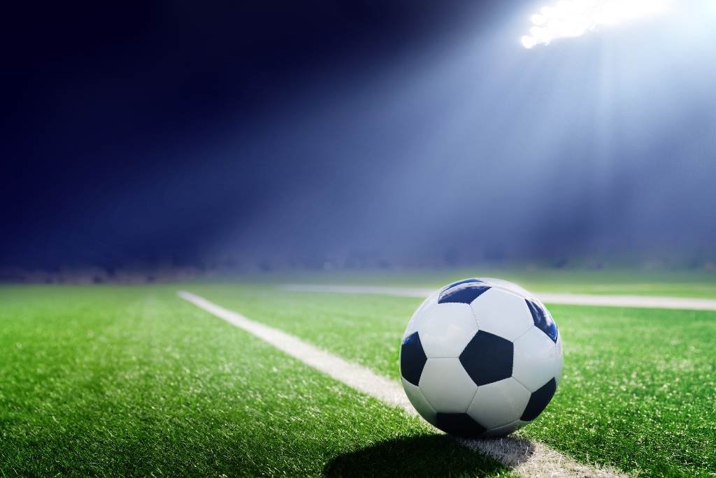 Soccer ball on a field under stadium lights, representing college soccer recruiting.