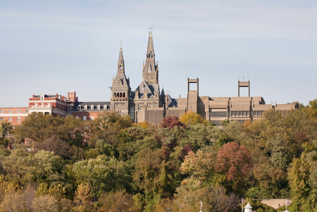 Georgetown University campus skyline with historic academic buildings surrounded by autumn trees.