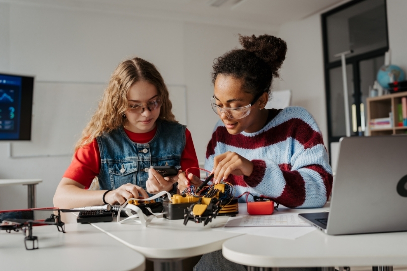 High school students working on an engineering extracurricular project with robotics and electronics.