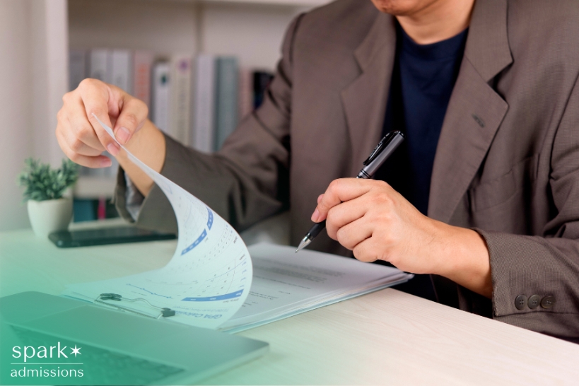 Admissions reviewer evaluating a high school transcript for grades and academic performance.
